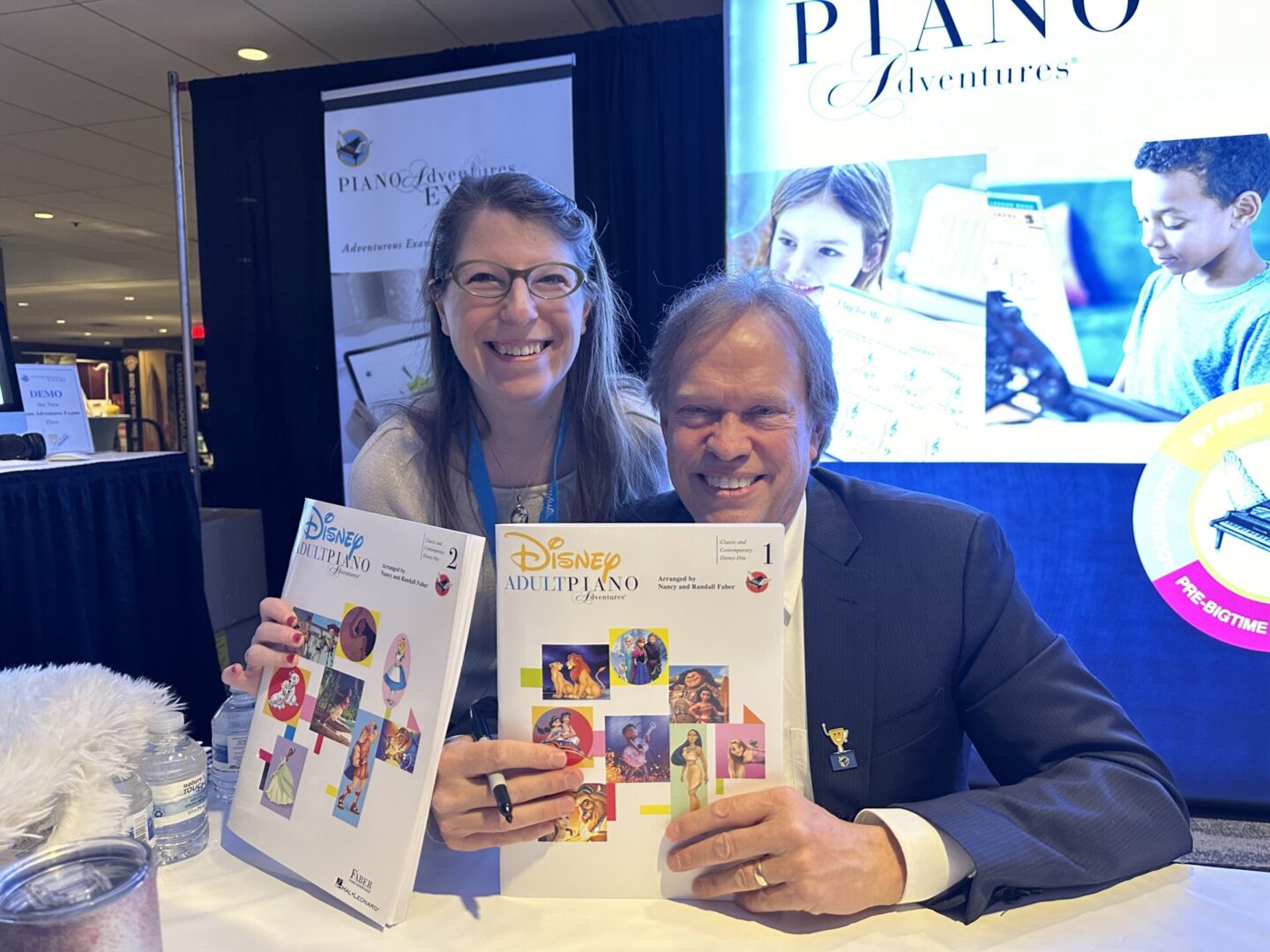 Two people holding a book and smiling.