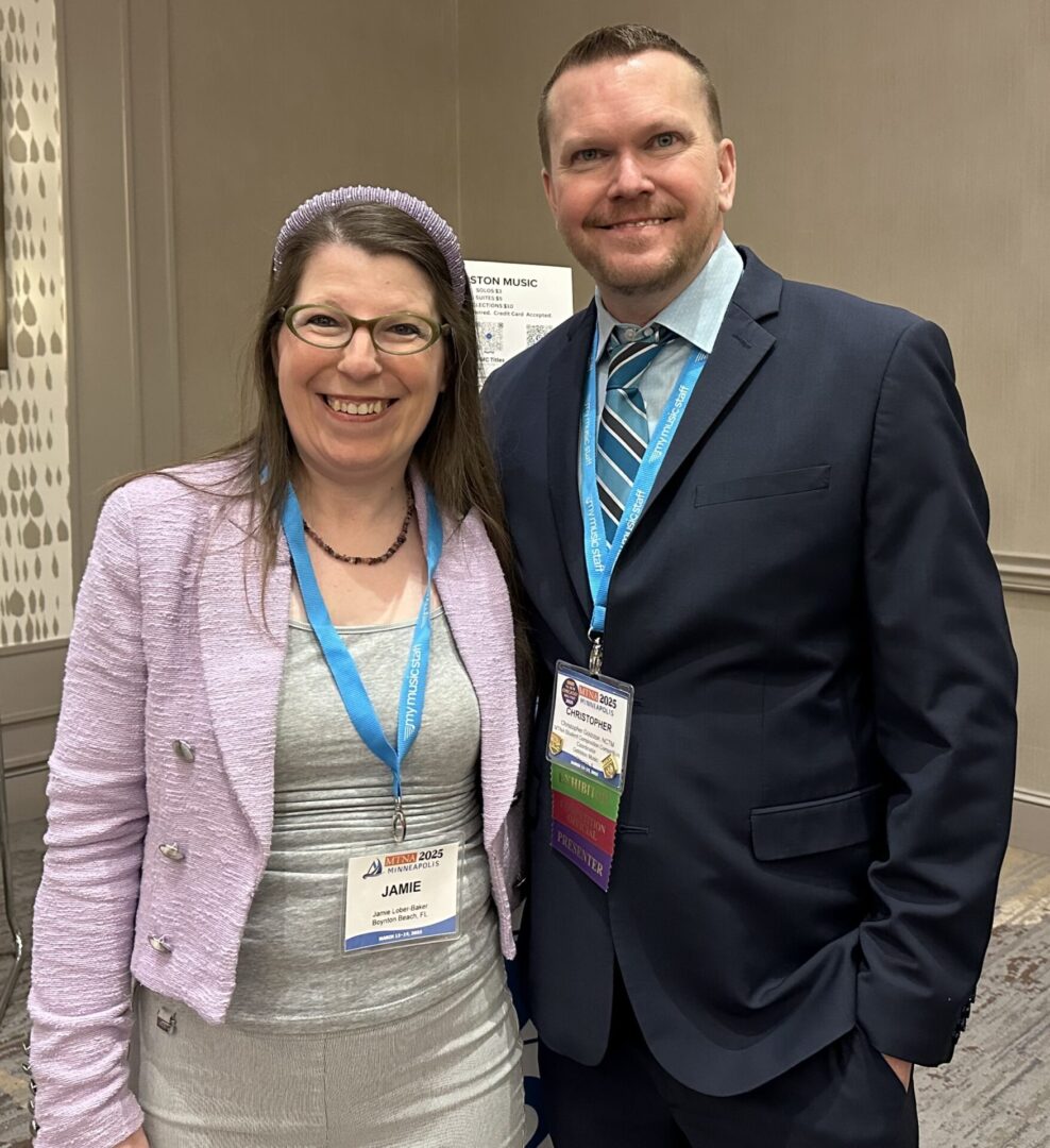 Two people smiling at a conference.