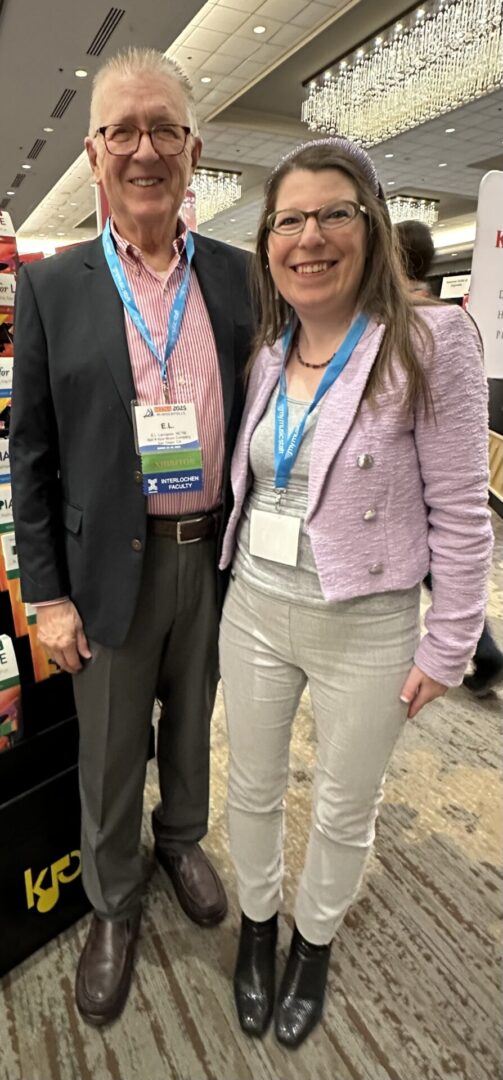Two people smiling at a conference.