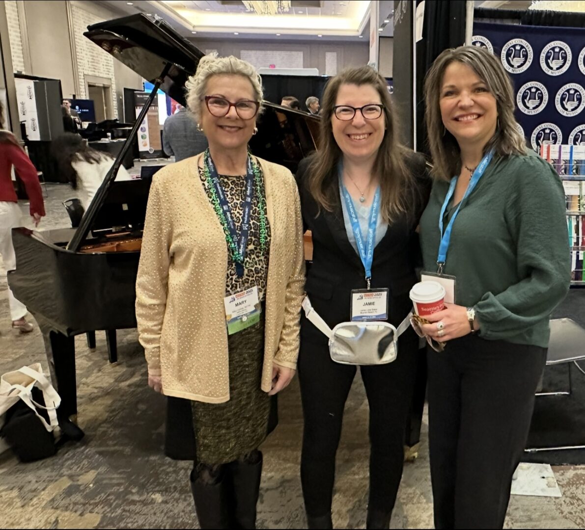 Three women smiling at conference event.